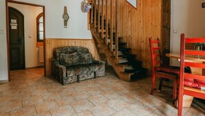 A room with a wooden staircase, a sofa, and a dining table. - Beautiful apartment for 4 people with pool, WIFI, TV and patio (Jablonec Nad Nisou)