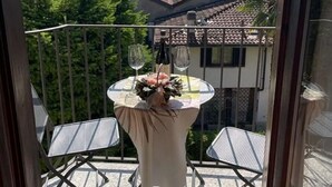 A balcony with a table set for two, overlooking a mountainous landscape. - Cosy apartment for 4 people with WIFI and balcony (Domaso)