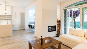 Ein modernes Wohnzimmer mit einem Holztisch, einem weißen Sofa und einem Essbereich mit Tisch und Stühlen.