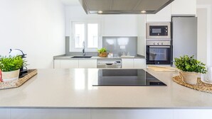 Una cucina moderna con isola centrale, elettrodomestici in acciaio inossidabile e piante in vaso.