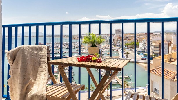 Un balcone con vista su un porto turistico e sullo skyline della città.