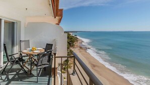 A balcony with a table and chairs overlooking a beach. - Lovely apartment for 4 people with pool, TV and terrace (Miami Platja)
