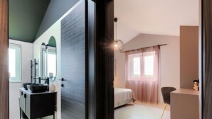 A modern bedroom with a bed, a bedside table, a window with curtains, and a bathroom with a sink and mirror. - Wonderful  villa for 6 people with private pool, A/C, WIFI, TV and terrace (Pazin)
