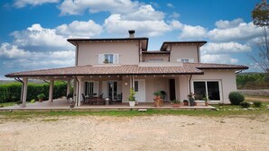 A two-story house with a tiled roof, a covered patio, and a garden. - Nice apartment for 2 guests with WIFI, A/C, TV and terrace (Noto)