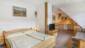 Ein Schlafzimmer mit Bett, Nachttisch, Lampe und einem Bild an der Wand.