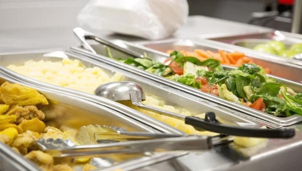 Un buffet proposant une variété de plats, notamment des salades, du riz et d’autres mets.