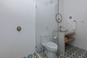 Une salle de bain avec des toilettes, un lavabo et une douche.