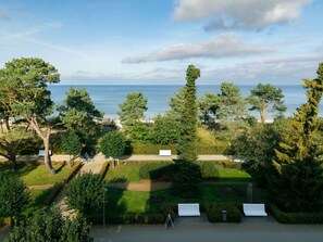 Enjoy serene views of the sea from a tranquil garden with a paved pathway and a bench for relaxation.