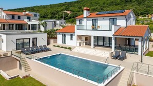A modern villa with a swimming pool, multiple balconies, and solar panels. - Awesome home in Trget (Trget)