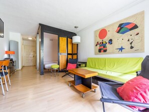 Relax in this stylish living space with a green sofa, wooden coffee table, and abstract art.
