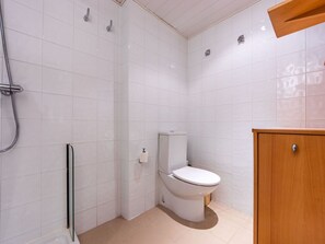 Bathroom features a toilet, shower area, and storage cabinet.