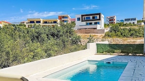A modern pool area with a clear blue pool, surrounded by a stone deck. - Beautiful private villa for 4 people with A/C, WIFI, TV and terrace (Zadar)