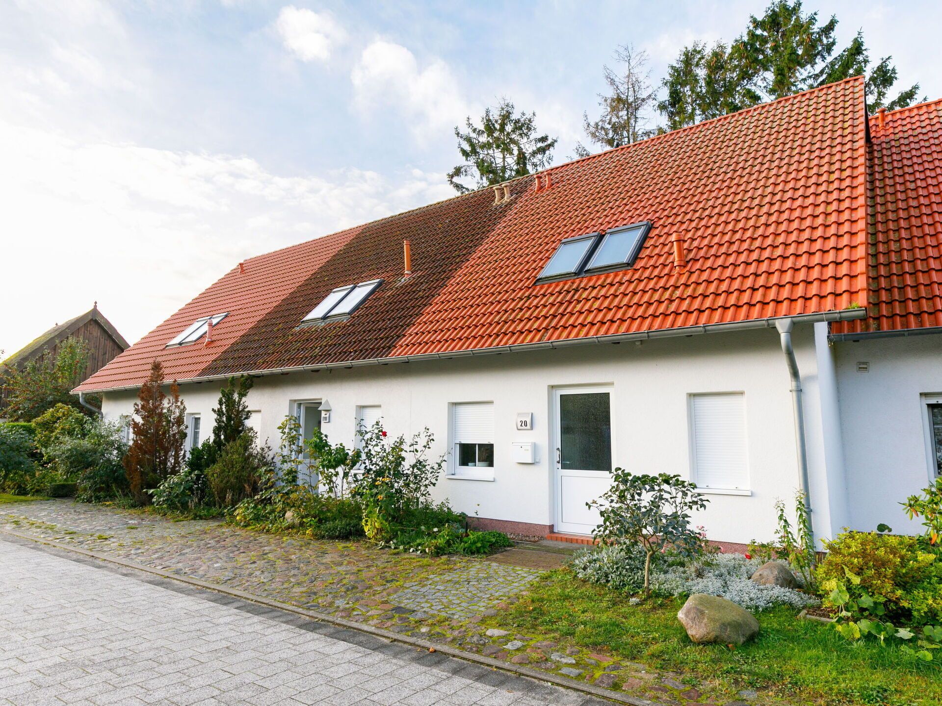 A row of white houses with red-tiled roofs and small windows.