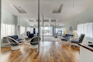 A spacious living area with a large window, a punching bag, and a treadmill.