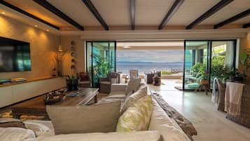 Departamento Deluxe, vista a la playa | Área de sala de estar | Televisión de pantalla plana de 60 pulgadas con canales por cable