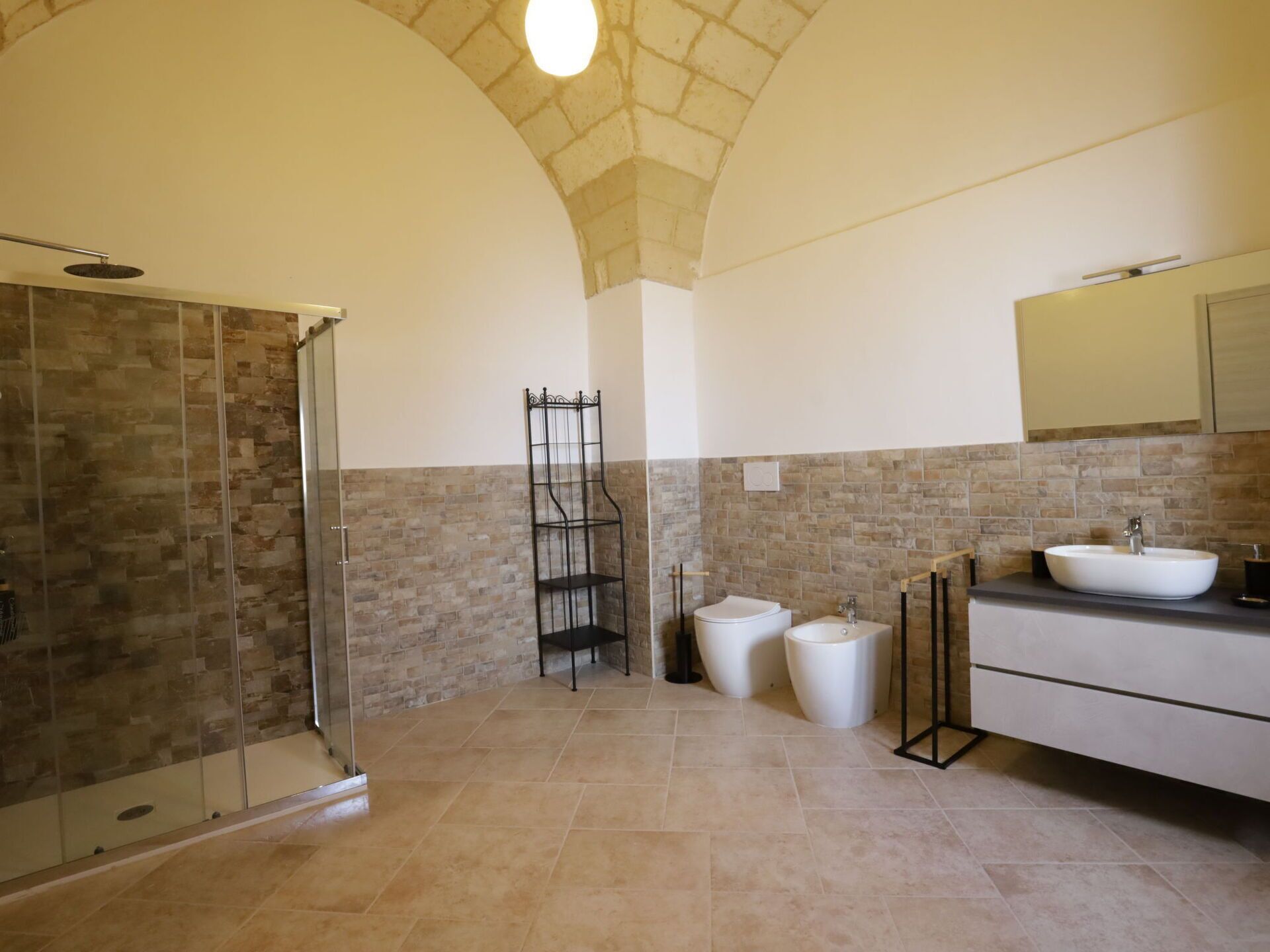 Een badkamer met een douche, wastafel en toilet.