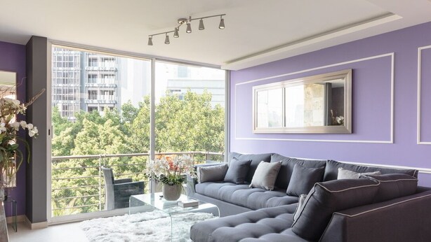 A modern living room with a grey sectional sofa, a glass coffee table, and a white furry rug. - Two Hip & Chic Apartments with Private Rooftop in Exclusive Roma Norte (Ciudad de México)