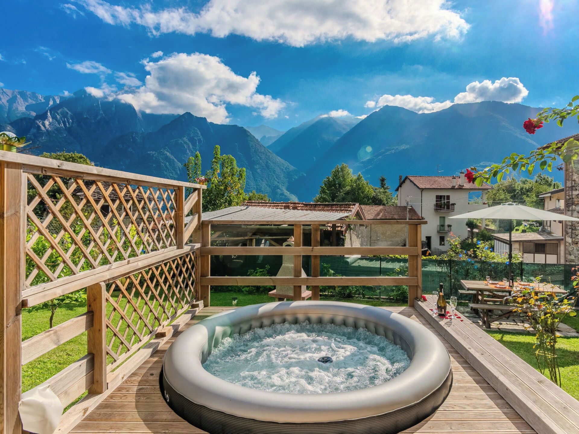 A hot tub on a wooden deck with a mountain view.