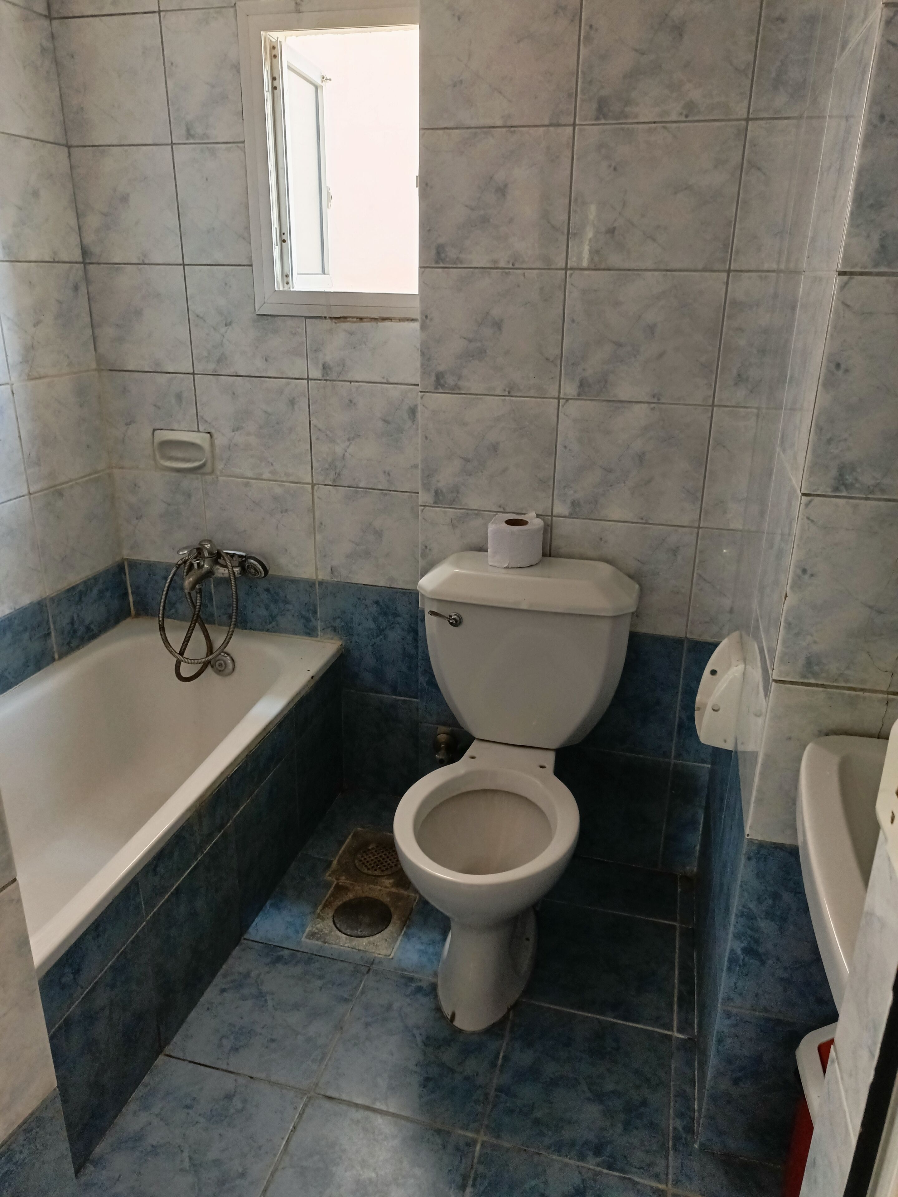 Um banheiro com banheira, vaso sanitário e janela.