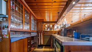 A bar area with wooden cabinets, a counter, and a glass display case. - Stunning private villa for 36 guests with WIFI, TV and terrace (Bayerisch Eisenstein)