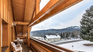 A wooden balcony with a view of a snow-covered landscape and buildings. - Stunning private villa for 36 guests with WIFI, TV and terrace (Bayerisch Eisenstein)
