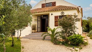 A two-story building with a tiled roof, a front door, and a small porch with steps leading up to it. - Beautiful private villa for 8 people with A/C, private pool, WIFI, TV, patio and pets allowed (Deltebre)