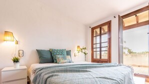A bedroom with a bed, bedside tables, a nightstand, a window, and a view of the outdoors. - Beautiful private villa for 8 people with A/C, private pool, WIFI, TV, patio and pets allowed (Deltebre)