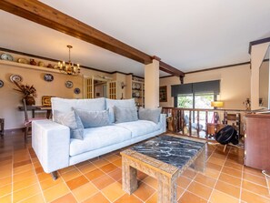 A living room with a light blue sofa, a wooden coffee table, and a tiled floor. - Beautiful private villa for 8 guests with WIFI, A/C, private pool, TV, terrace and pets allowed (El Vendrell)