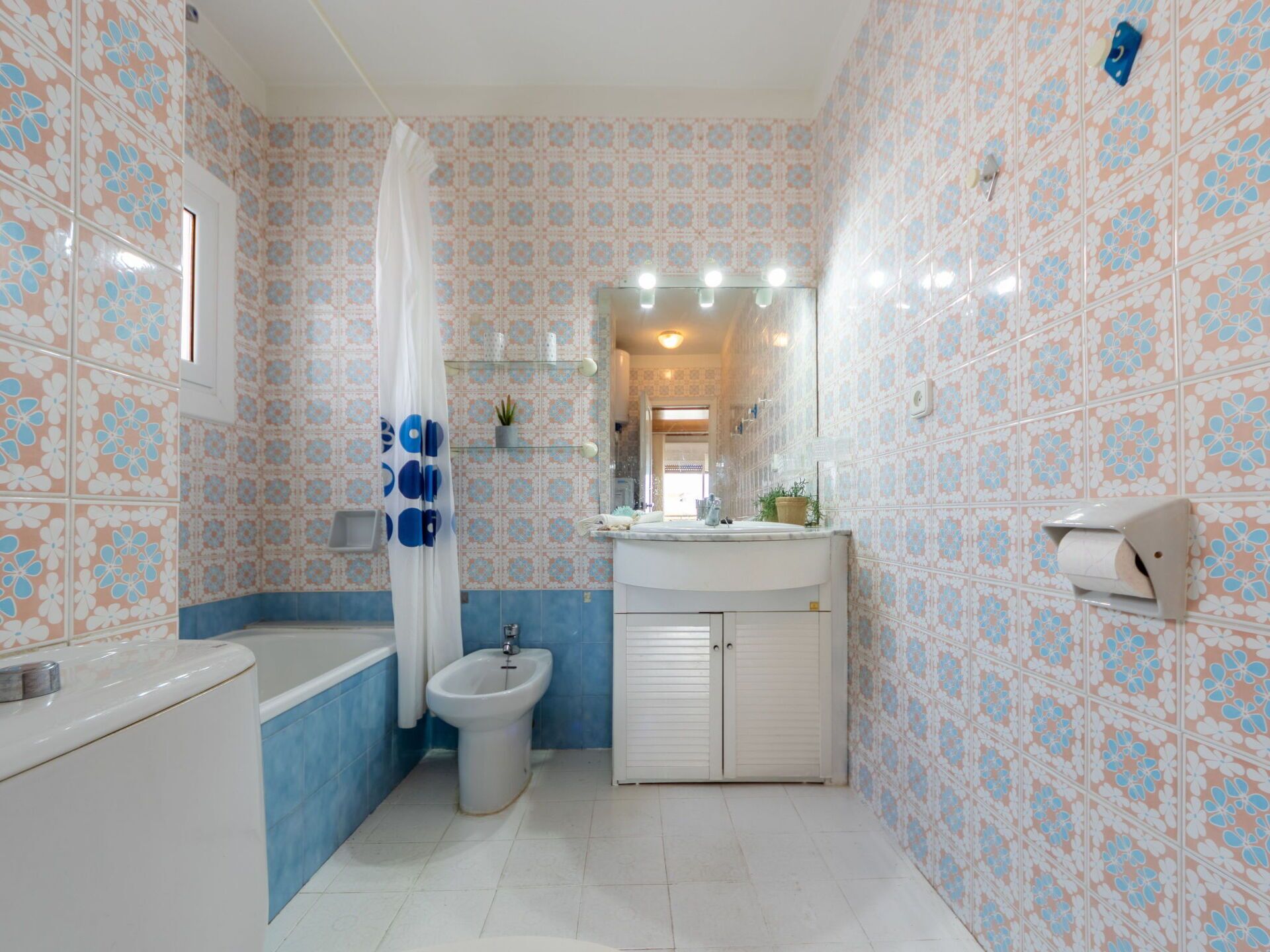 A bathroom with a bathtub, a bidet, a toilet, and a sink.