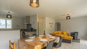 Une cuisine moderne avec un coin repas, un canapé et un fauteuil.