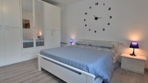 A bedroom with a bed, a wardrobe, a wall clock, and bedside lamps. - Beautiful apartment for 6 people with WIFI, A/C, TV and pets allowed (Cosio Valtellino)