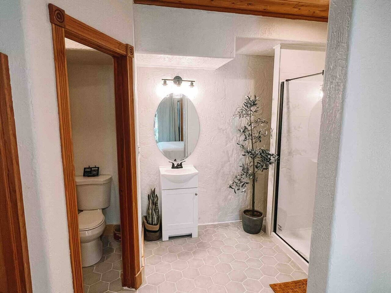 Ein Badezimmer mit Toilette, Waschbecken, Spiegel und Dusche.