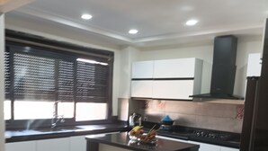 Una cocina moderna con armarios blancos, encimera negra y una pequeña isla.