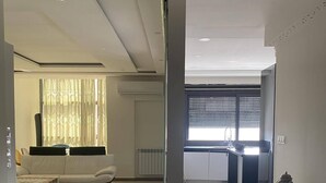 Amplia sala de estar con sofá, una mesa de centro y una mesa de comedor con adornos.