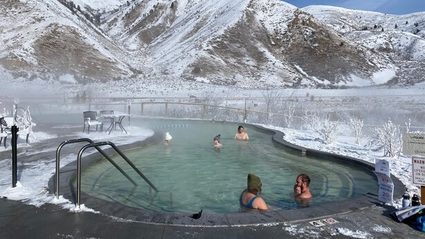 Una sorgente termale circondata da montagne innevate.