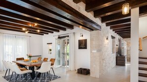 A spacious dining area with a wooden table and chairs, a black and white rug, and a view of the outdoor balcony. - Wonderful private villa with private pool, WIFI, A/C, TV, terrace, pets allowed and panoramic view (Pazin)