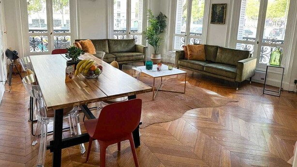 A spacious living room with a wooden dining table, two sofas, and a coffee table.