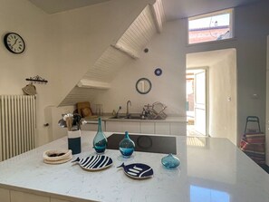 Een oven, een vaatwasser, een broodrooster, eettafels