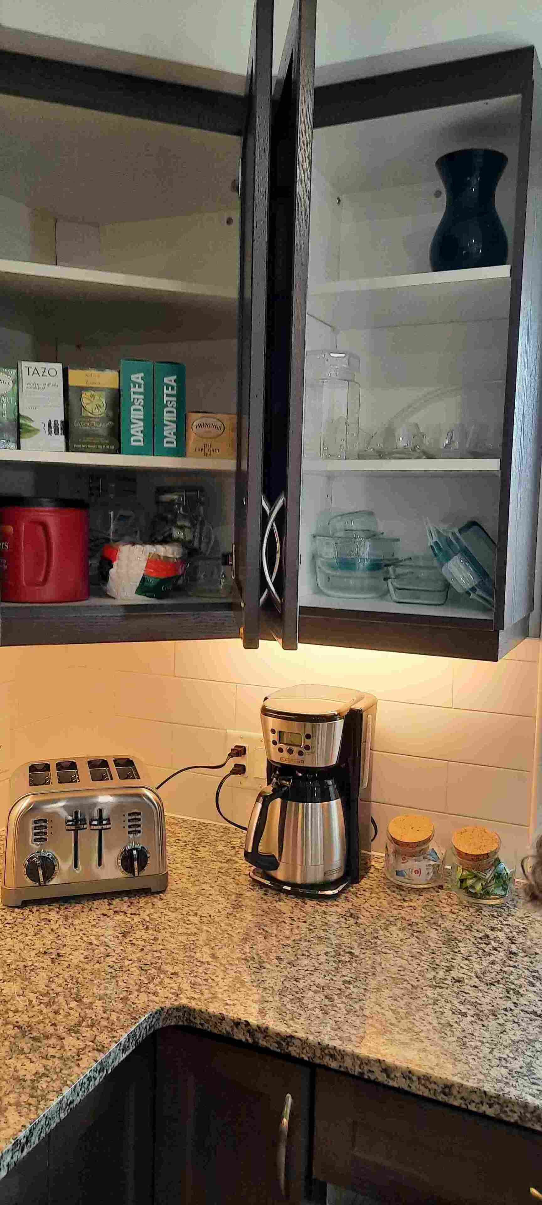 Eine Küche mit Toaster, Kaffeemaschine und Gläsern auf der Arbeitsfläche.