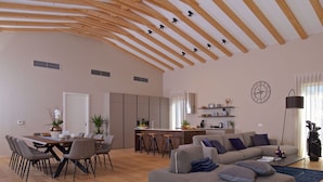 A spacious living area with a high wooden ceiling, a dining table with chairs, a sofa, a coffee table, and a kitchen area in the background. - Beautiful private villa with A/C, WIFI, hot tub, private pool, TV, terrace and pets allowed (Umag)
