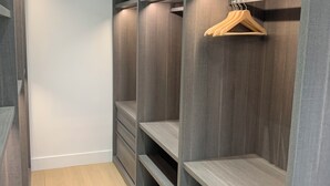 A walk-in closet with multiple shelves and a wooden hanger. - Beautiful Divonne Home in the Heart of the town and totally Private! (Divonne-les-Bains)