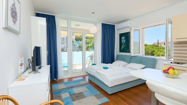 Un dormitorio moderno con cama, escritorio y zona de comedor.