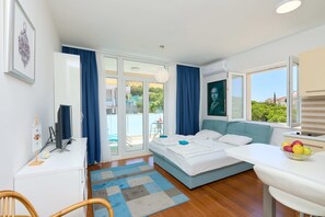 A modern bedroom with a bed, a desk, and a dining area. - Lino Suite (Dubrovnik)