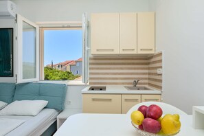 Una cocina pequeña con ventana, un lavamanos y una encimera.