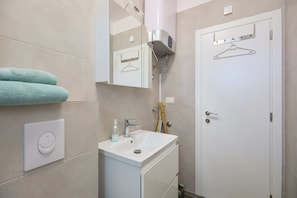 Klassieke studio | Badkamer | Een douche, een haardroger, handdoeken