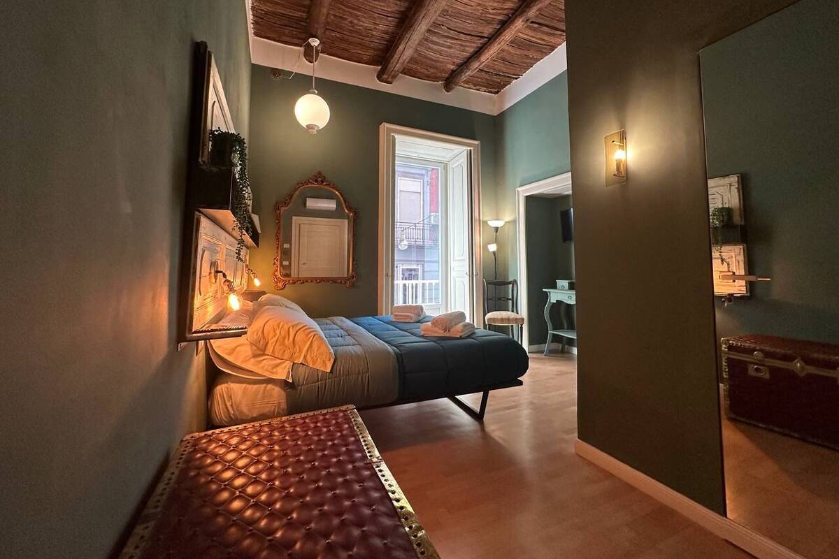 Un dormitorio con cama, mesita de noche y vistas al exterior.