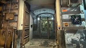 An arched entrance with a metal gate, a stone wall with a 'MR' sign, and a poster on the wall. - I Leoni di Rosaroll (Naples)