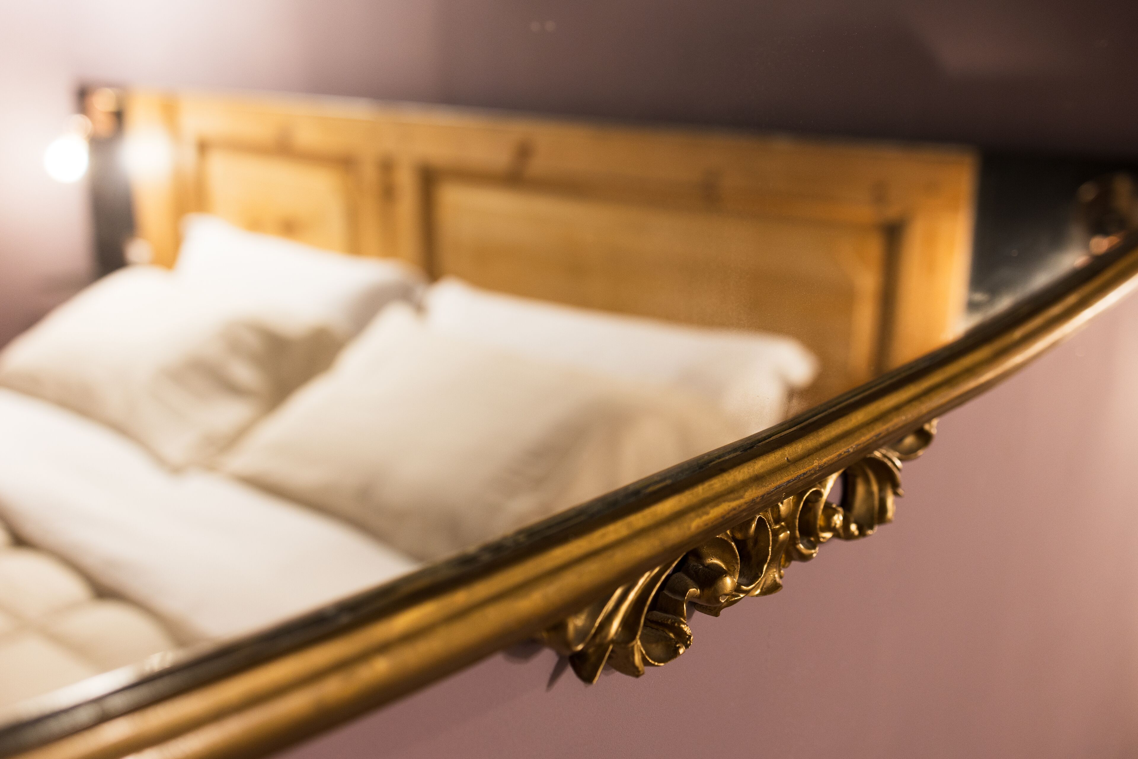 Una cama con cabecera de madera y almohadas blancas.