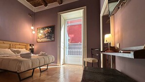 A bedroom with a bed, bedside table, chair, and a painting on the wall. - I Leoni di Rosaroll (Naples)