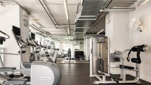 A gym with treadmills, elliptical machines, and weightlifting equipment.